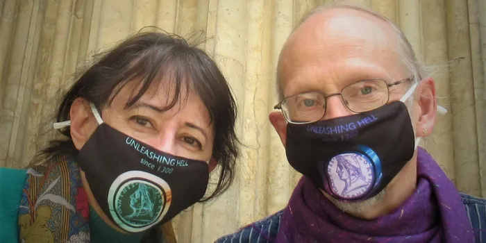 Woman with brown hair and man with grey hair pose with facemasks on