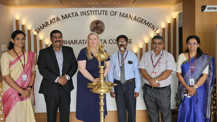 A group of six people posing at the Bharata Mata Institute of Management in India.