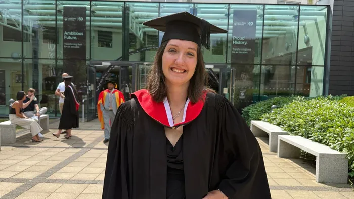 A graduate in front of the Horsforth Campus