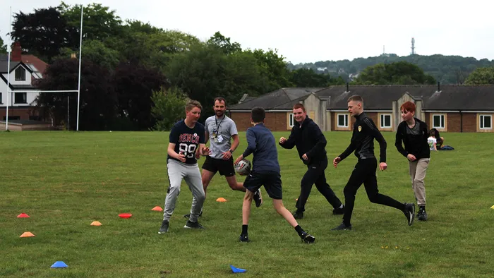 A group of school children playing football.