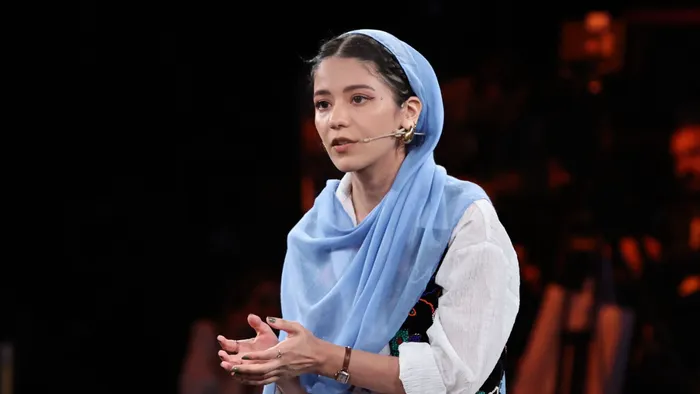 Young woman wearing a blue scarf giving a talk