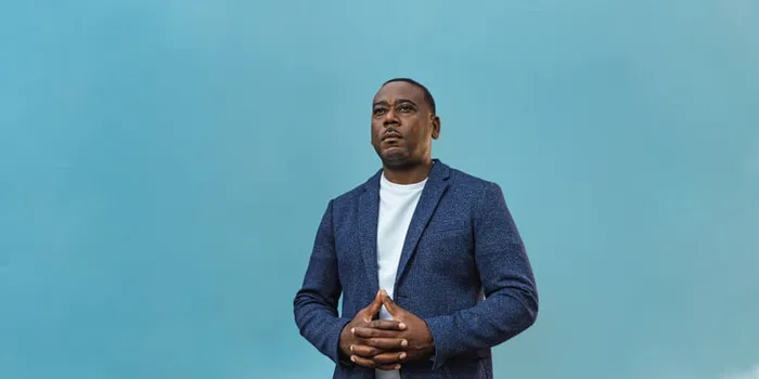 Man standing on stage with hands crossed