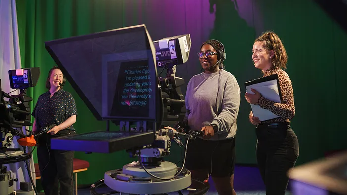 Students working on a prompter in the TV studio.