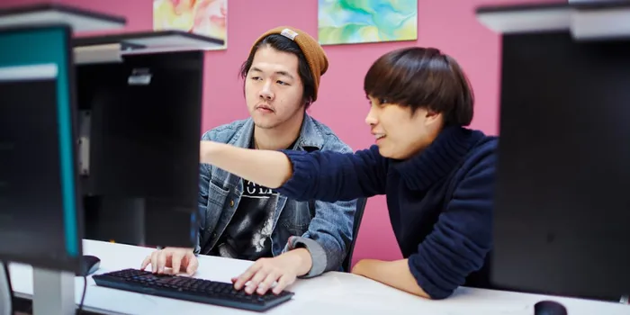 Two male students sat at computer screen