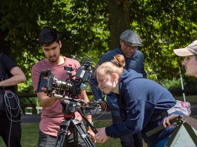 4 students and staff on set filming
