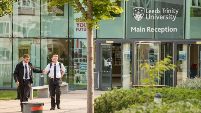 Two trainee prison officers in uniform walking outside University entrance