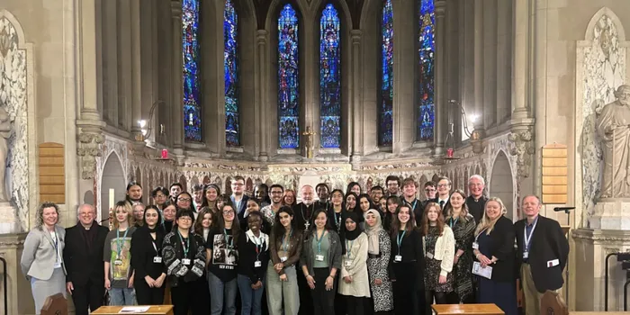 students and staff standing together in a chapel for a photograph
