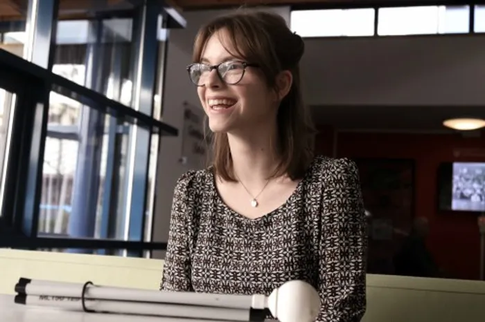 Chloe Tear sat at table with white cane