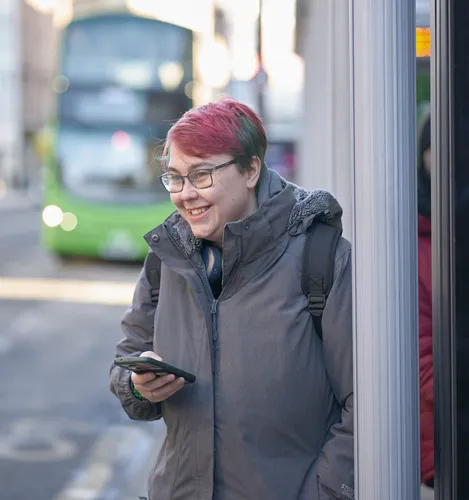 Student waits at bus stop in Leeds City Centre