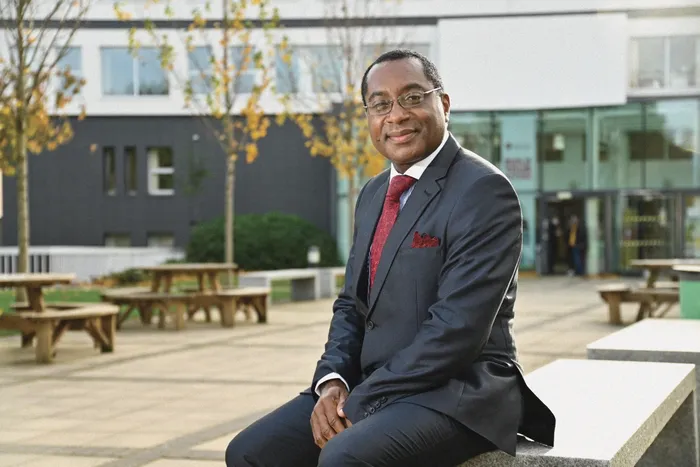 Leeds Trinity University Vice Chancellor sat on a bench outside Main Campus.