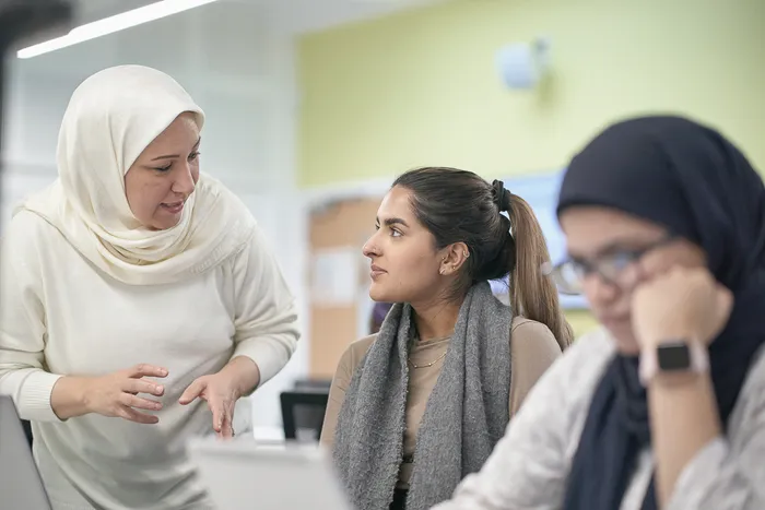 Student talking with lecturer in computer suite