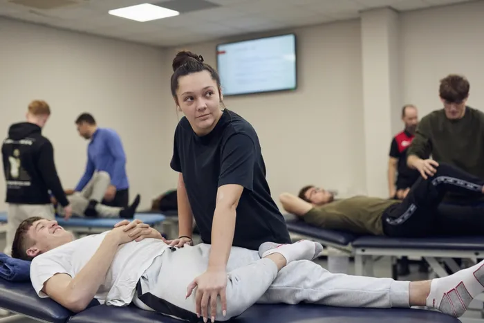 Student giving sports therapy session.