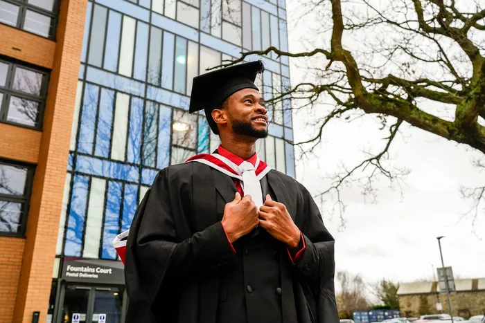 Graduate standing outside Fountains Court.